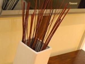 a white vase filled with sticks sitting on a table at The New Inn in Reading