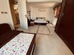 um pequeno quarto com uma cama e um sofá em Maldives villa em Raʼs Matarma
