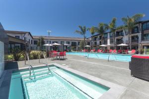 una piscina en un hotel con mesas y sombrillas en Sunnyvale studio w pool ac wd nr freeways SFO-1142, en Sunnyvale