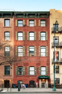 a large red brick building with windows on a street at Chelsea Pines Inn in New York