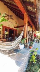 a hammock in front of a resort with a restaurant at Urbanos Hostel in Santa Catalina