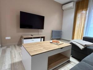 uma sala de estar com uma mesa e uma televisão de ecrã plano em ACENI em Ciudad Real