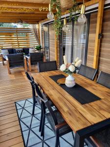 una mesa de madera con sillas y un jarrón de flores en PAMARA Mobile Home, en Biograd na Moru