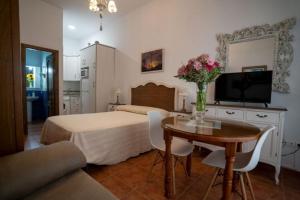 a bedroom with a bed and a table with flowers on it at La Posada De Carmen in Níjar