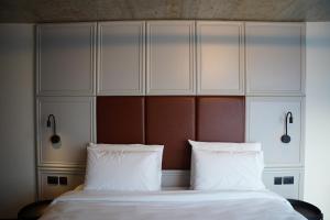 a bedroom with a large bed with white pillows at The Londoner Hotel Sliema in Sliema