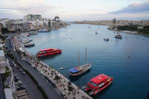 a view of a river with boats in a city at The Londoner Hotel Sliema in Sliema