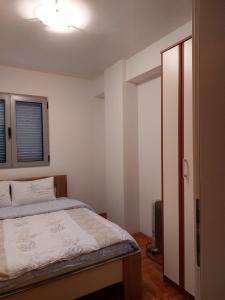 um quarto com uma cama e uma porta aberta em Apartment Rozino em Budva