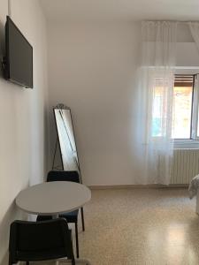 a room with a table and a tv and a window at Adults only Beachhouse Pineto zona Corfu in Pineto
