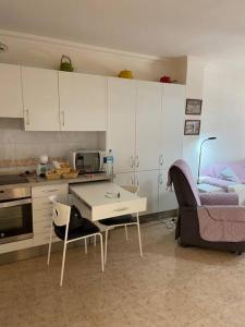 a kitchen with a table and a chair and a couch at Apartamento Casa Barbara in Puerto de la Cruz