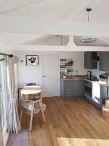 a kitchen with a table in the middle of a room at The Lodge in High Legh