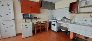 a small kitchen with a white refrigerator and a stove at Habitación con baño privado acceso a cocina y terraza en Miraflores in Lima +26 photos