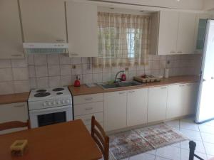 a kitchen with a stove and a sink and a table at Stefkas apartment1 in Patra