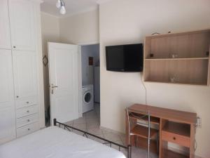 a bedroom with a bed and a desk and a tv at Stefkas apartment1 in Patra