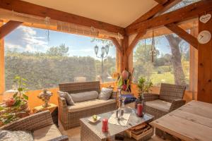 un porche cubierto con muebles y una ventana grande en Villa Catalpa, en Le Muy