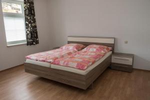 1 dormitorio con 1 cama y suelo de madera en Ferienwohnung Otto en Klingenthal