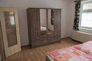 1 dormitorio con tocador, cama y espejo en Ferienwohnung Otto en Klingenthal