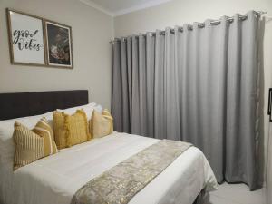 una camera da letto con un grande letto con tende grigie di 93 on new unique and classy a Midrand