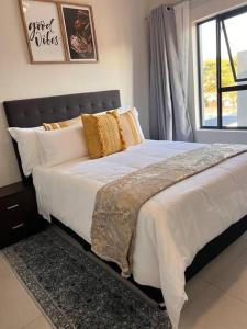 1 cama grande en un dormitorio con ventana en 93 on new unique and classy en Midrand