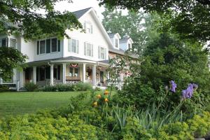a white house with a garden in front of it at Maple Shade Bed & Breakfast 