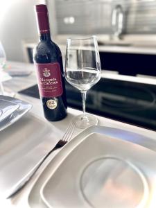 uma garrafa de vinho e um copo sobre uma mesa em Villa turística Camina y Rioja em Cenicero