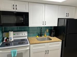 a kitchen with white cabinets and a black refrigerator at Breakers Resort in Myrtle Beach