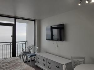 a bedroom with a bed and a tv on the wall at Breakers Resort in Myrtle Beach