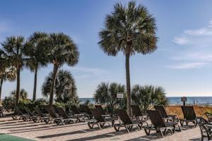 a row of chairs and palm trees on a beach at Breakers Resort in Myrtle Beach