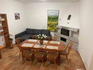 a living room with a table and chairs and a couch at Hiša Pod Slavnikom in Podgorje