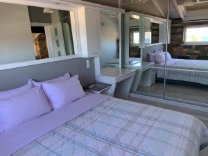 a bedroom with a bed and a large mirror at Almyri seafront flat in Káto Almirí