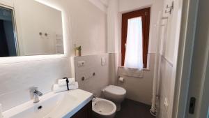 a white bathroom with a toilet and a sink at NUMANA SEA APARTMENT in Numana