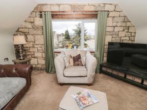 a living room with a couch and a chair and a television at Butterchurn Apartment in Newcastle upon Tyne