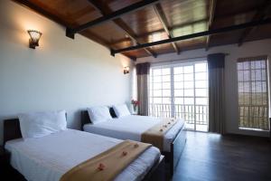 a bedroom with two beds and a large window at Terrabella - Nuwara Eliya in Nuwara Eliya