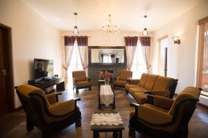a living room with couches and chairs and a fireplace at Terrabella - Nuwara Eliya in Nuwara Eliya