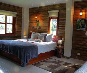 a bedroom with a bed in a room with wooden walls at HOTEL IGUAIMA in Ibagué
