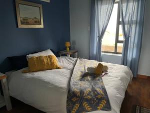 a bedroom with a bed with a blanket and a window at Seafront house in Swakopmund