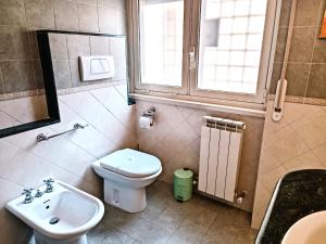 bagno con lavandino, servizi igienici e finestra di Appartamento luminoso Villa Pamphili a Roma