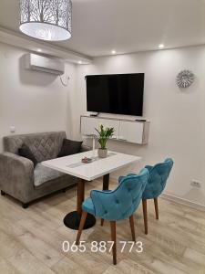 a living room with a table and a couch at City Break Apartment in Banja Luka