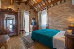1 dormitorio con cama y pared de ladrillo en Casale Vincenzo Country House, en Collecorvino