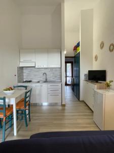 a kitchen with white cabinets and a table with chairs at Piccolo paradiso in Costa Paradiso