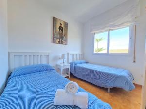 1 dormitorio con 2 camas y ventana en CABO DE PALOS ATICO LA GALERA parking, en Cabo de Palos