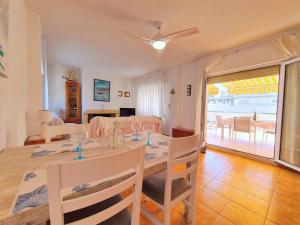 a dining room and living room with a table and chairs at CABO DE PALOS ATICO LA GALERA parking in Cabo de Palos