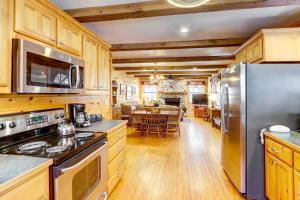 une cuisine avec des armoires en bois et des appareils en acier inoxydable dans l'établissement Lakefront Blue Ridge Cabin with Hot Tub!, à Blue Ridge