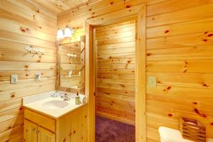 une salle de bain en rondins avec un lavabo et un miroir dans l'établissement Lakefront Blue Ridge Cabin with Hot Tub!, à Blue Ridge 19 autres photos