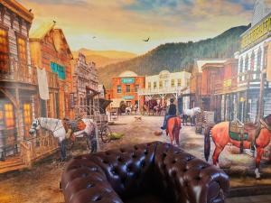 ein Gemälde einer Stadt mit Pferden auf einer Straße in der Unterkunft Western Cottage Hocheifel in Wirft