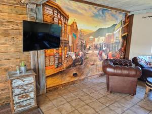 a living room with a wall mural of a city at Western Cottage Hocheifel in Wirft