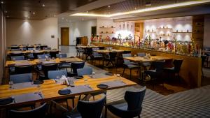 a restaurant with wooden tables and chairs and a bar at Sree Fortune Grand, Tadepalli in Tādepalle