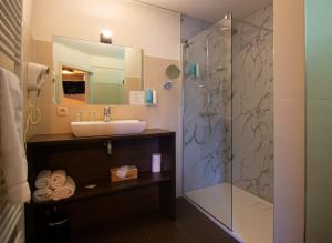 a bathroom with a sink and a shower at Hotel De Klok in Zutendaal