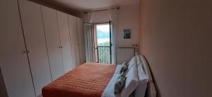 een kleine slaapkamer met een bed en een raam bij Ca' Eli 2 in Oliveto Lario