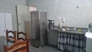 a kitchen with a stainless steel refrigerator and a sink at HOSTEL SANTOS PRAIA in Santos