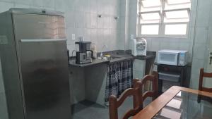 a small kitchen with a refrigerator and a microwave at HOSTEL SANTOS PRAIA in Santos